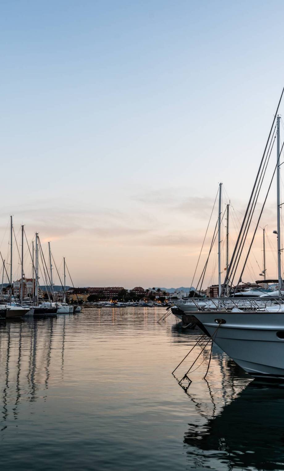 Luxury yachts moored in Marina of Mediterranean harbour at sunset. Denia, Alicante, Spain