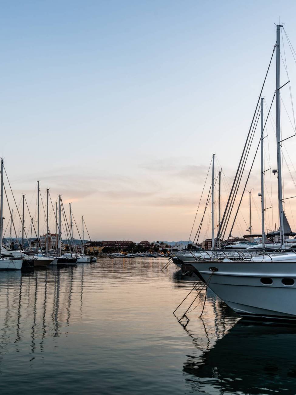 Luxury yachts moored in Marina of Mediterranean harbour at sunset. Denia, Alicante, Spain