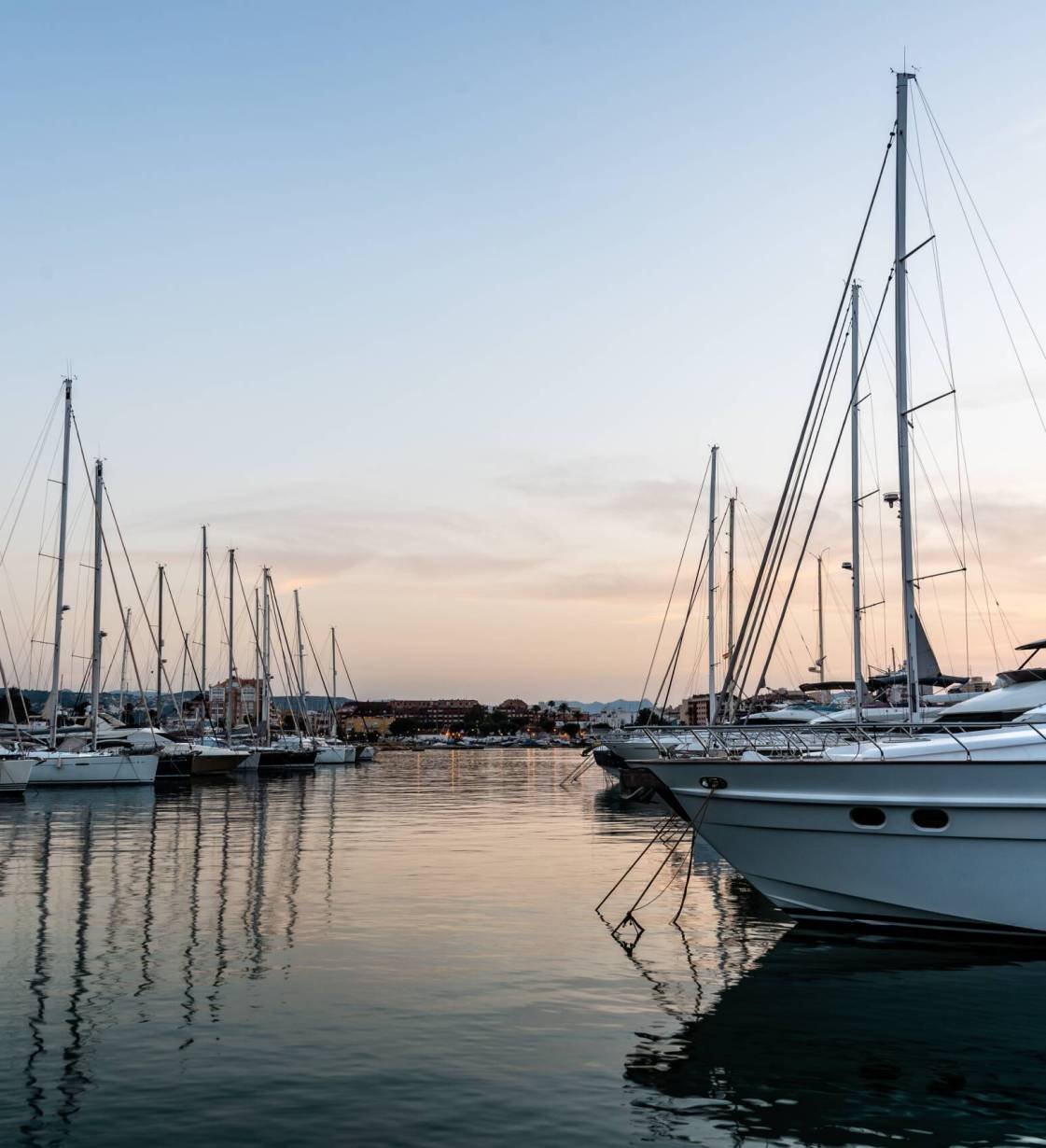 Luxury yachts moored in Marina of Mediterranean harbour at sunset. Denia, Alicante, Spain