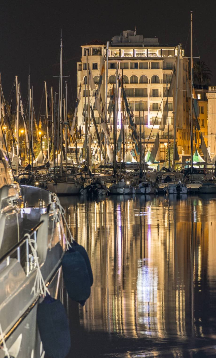Yachts in the cannes bay at night.  Illuminated buildings